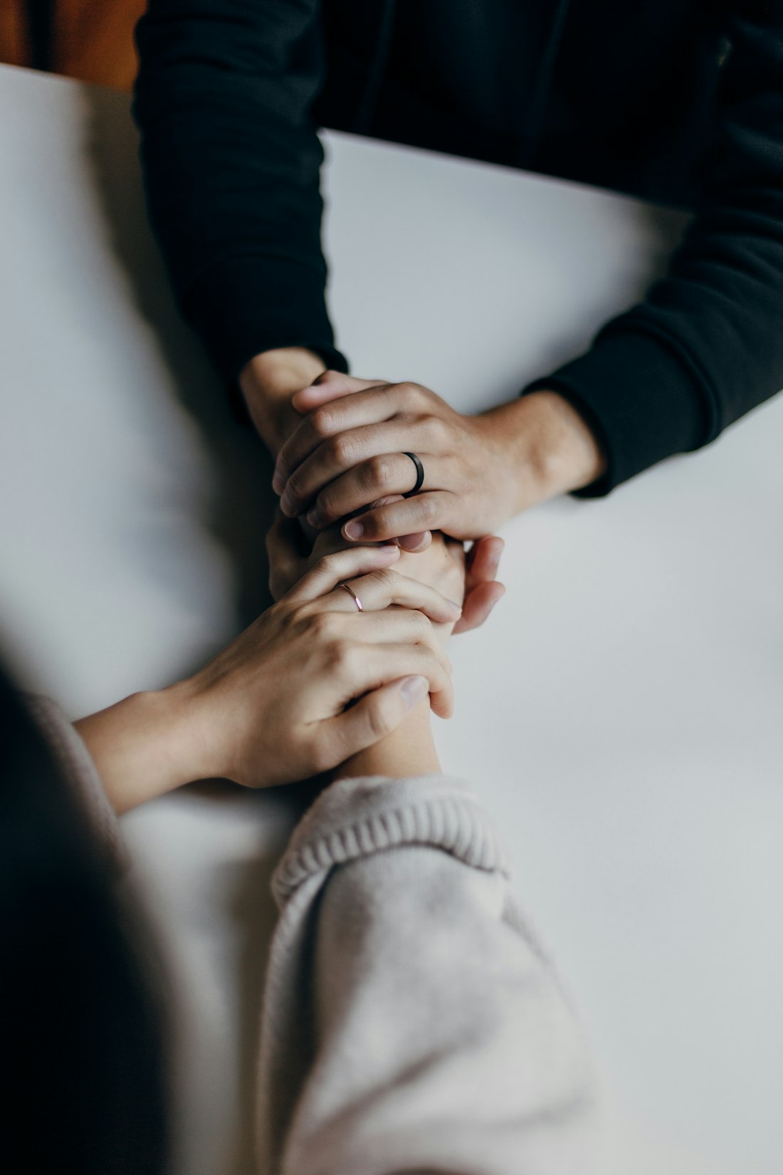 Two people holding hands across a table.